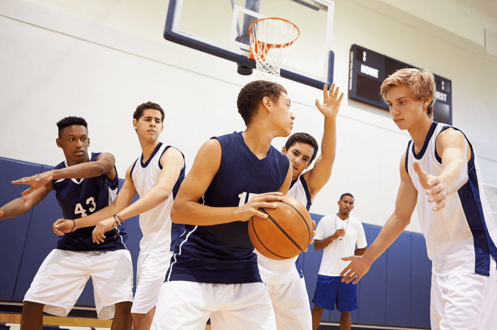 high schoolers playing basketball