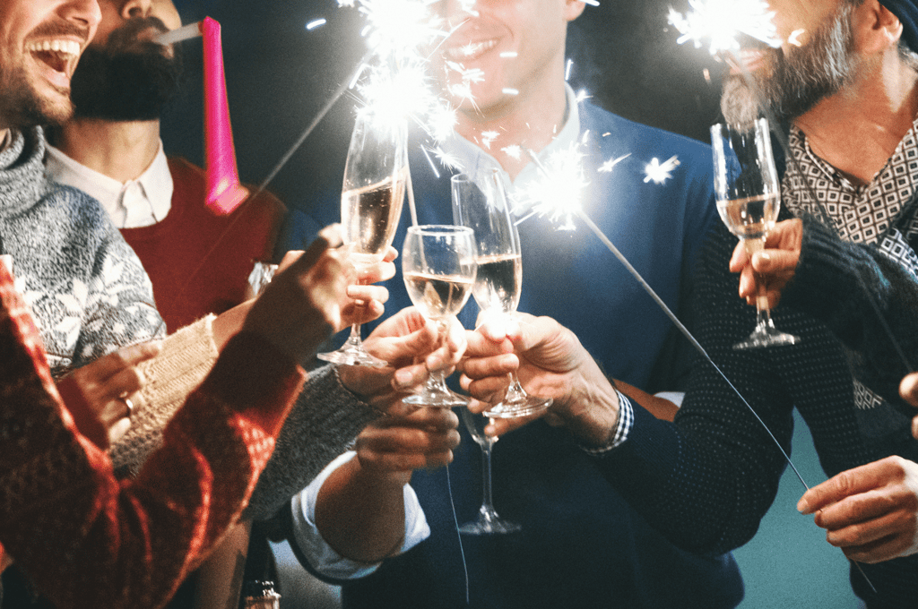 People tapping glasses together at party