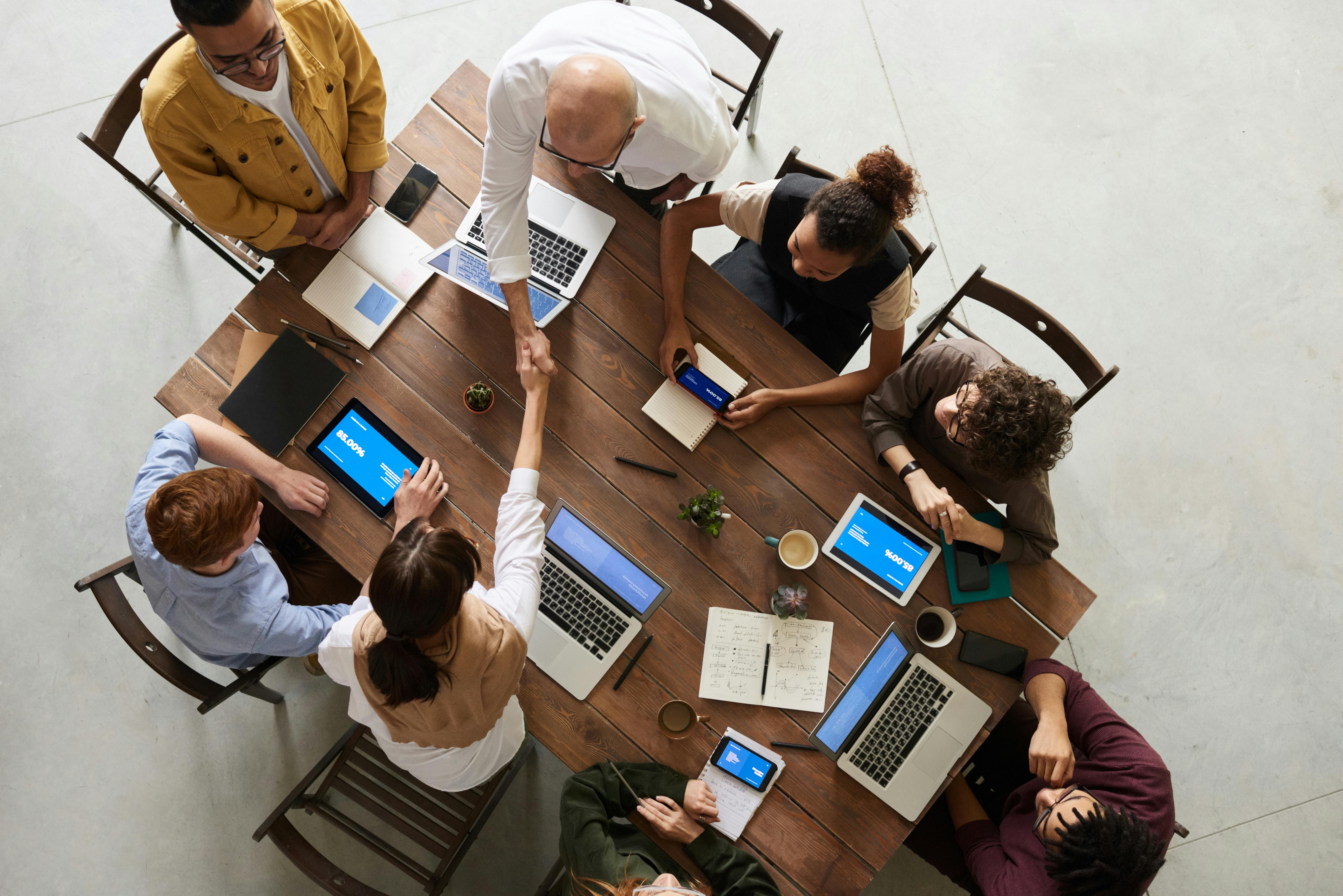 group of employees meeting with laptops and tablets